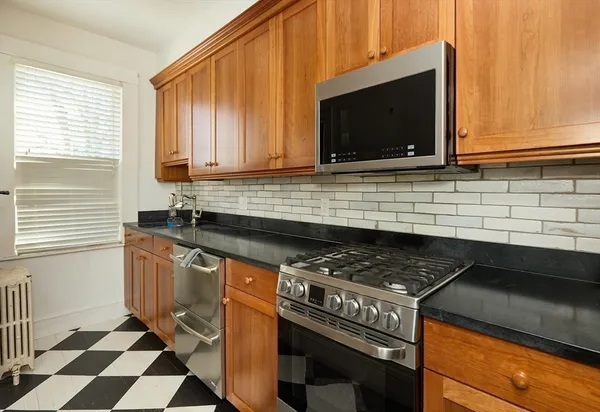 a kitchen with stainless steel appliances a sink a stove and cabinets