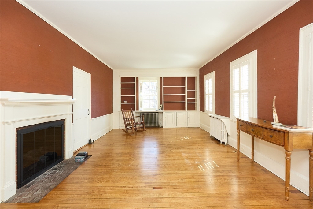 685 Highland Street Marshfield, MA 02050 - Photo 16 of 38 a view of an empty room with a fireplace and a large window
