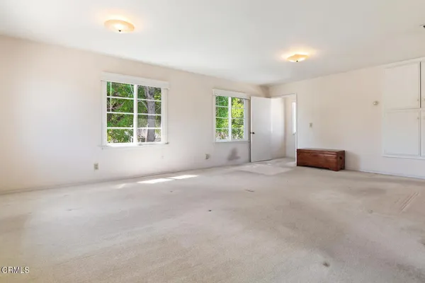 an empty room with a window and a kitchen