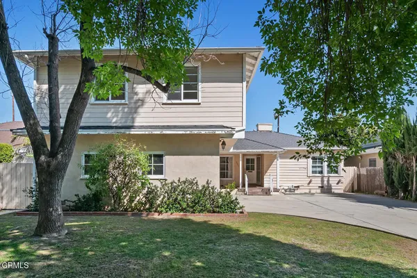 a view of a house with a yard patio and a tree