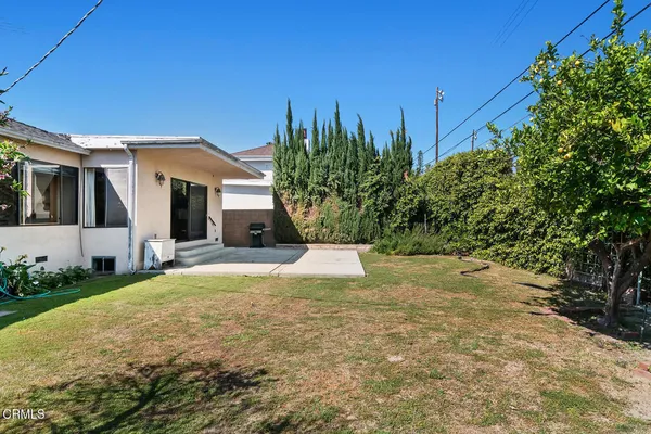 a view of a house with backyard and trees