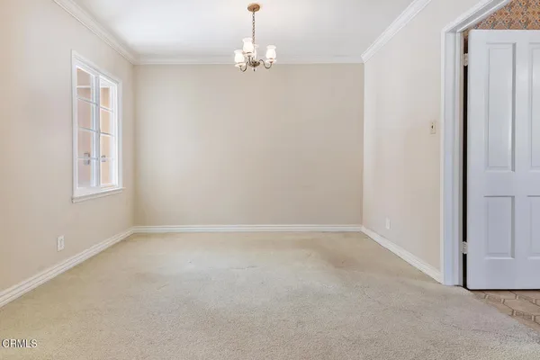 an empty room with windows and chandelier