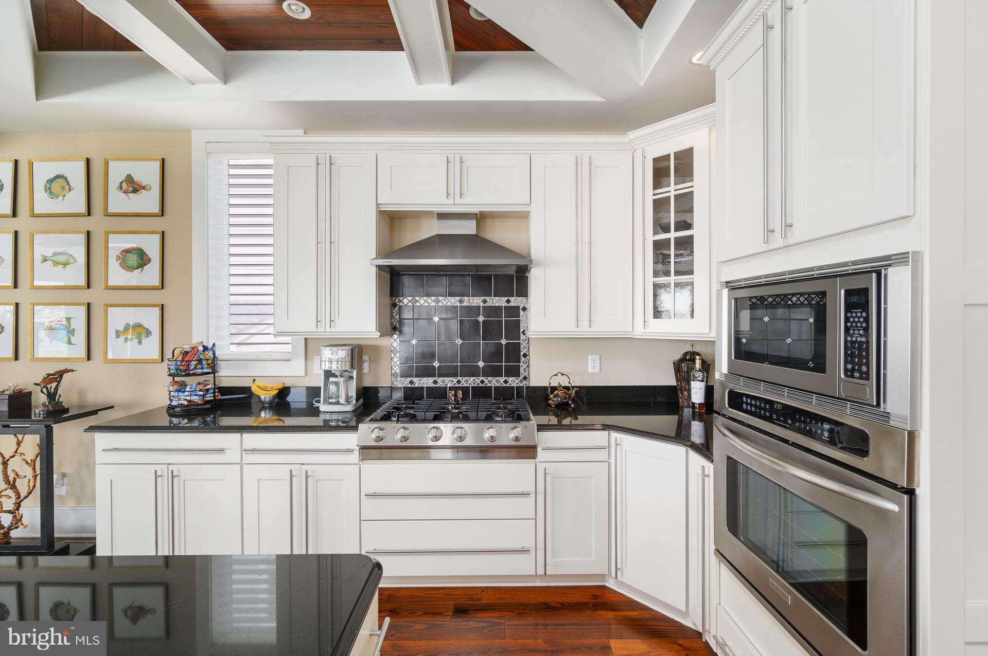 160 Channel Buoy Road Ocean City, MD 21842 - Photo 11 of 71 a kitchen with stainless steel appliances a stove sink microwave and cabinets