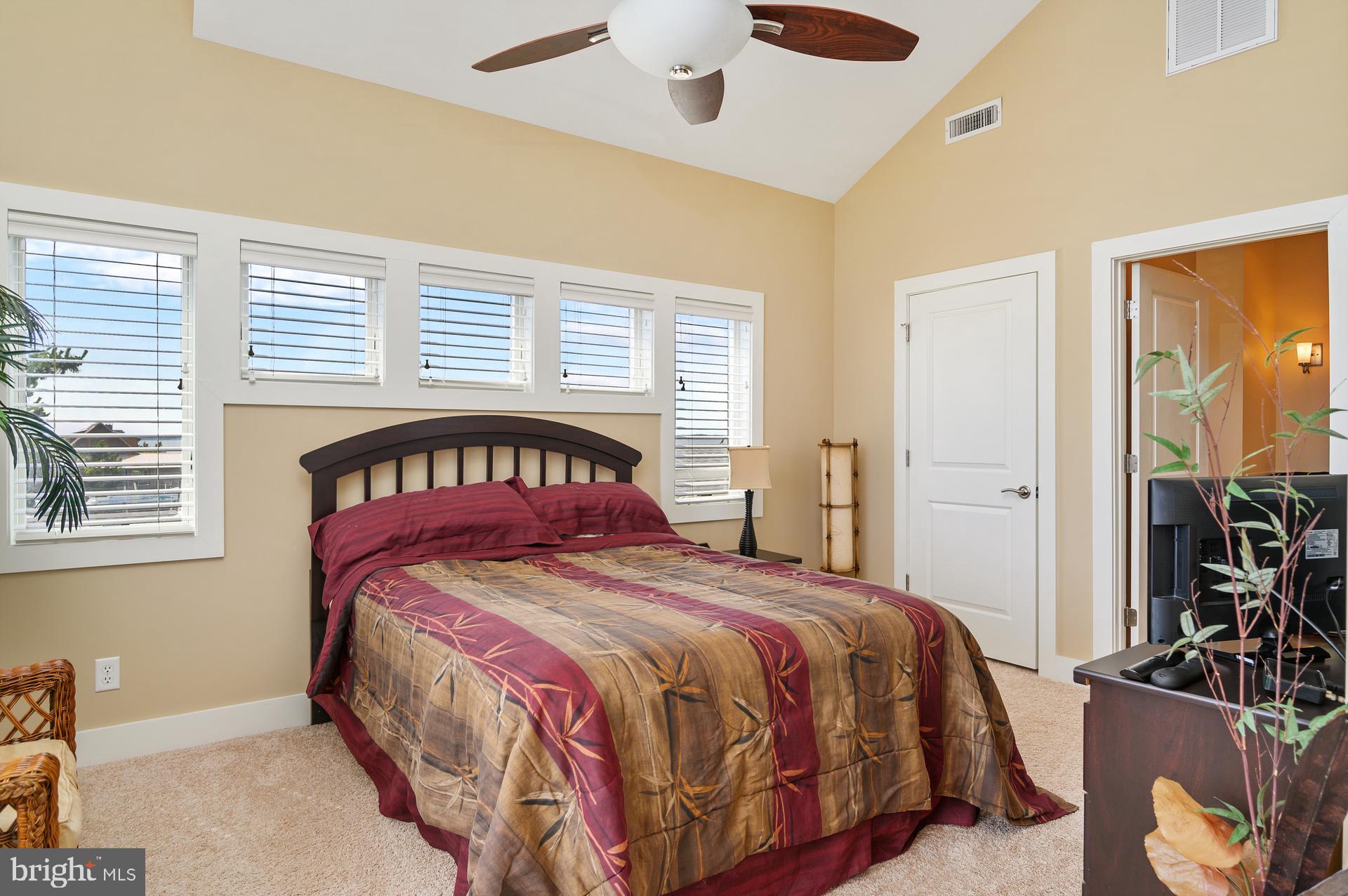 160 Channel Buoy Road Ocean City, MD 21842 - Photo 27 of 71 a bedroom with a large bed and a chandelier