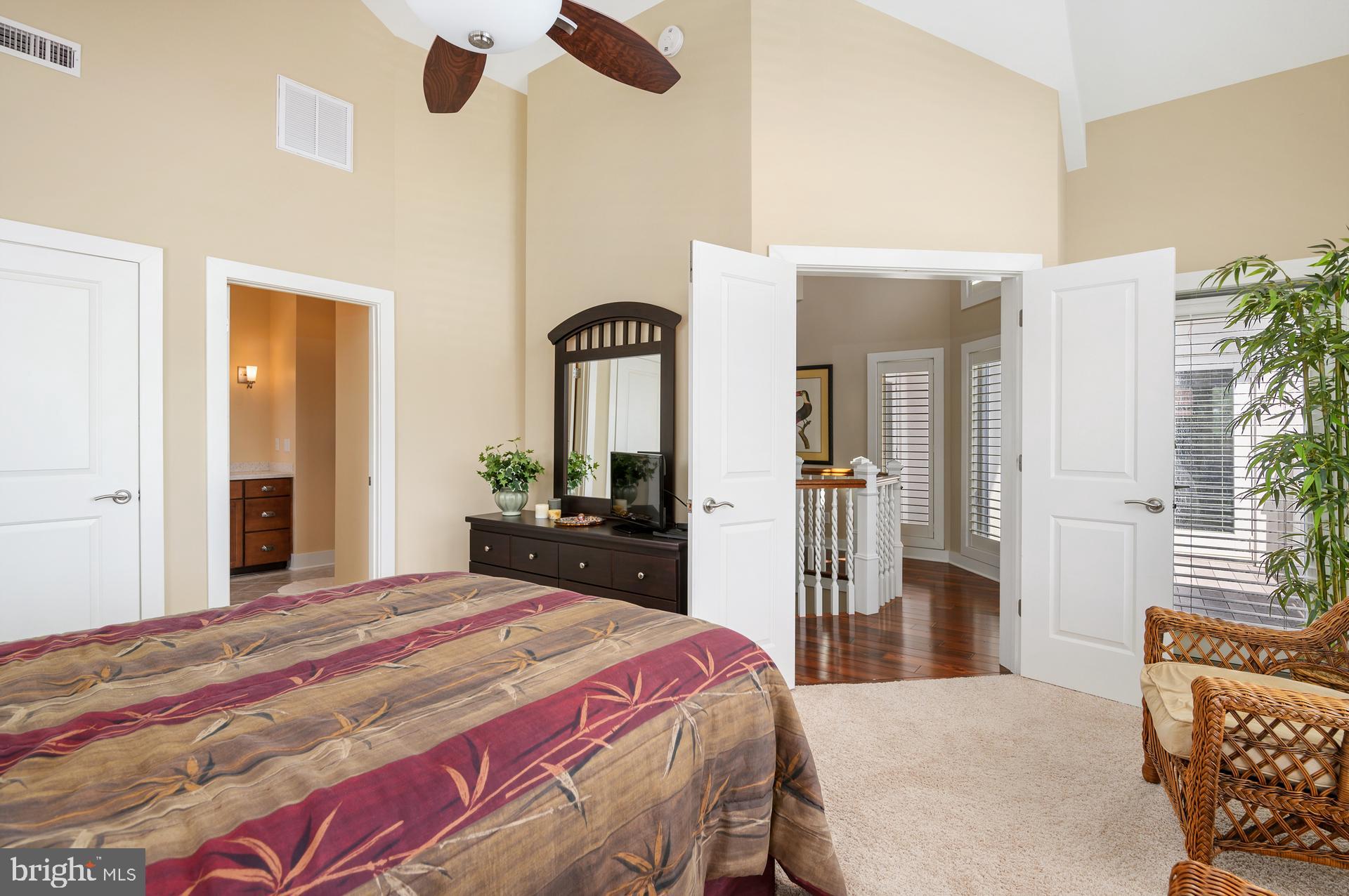160 Channel Buoy Road Ocean City, MD 21842 - Photo 29 of 71 a bedroom with a bed and a large mirror with a flat tv screen