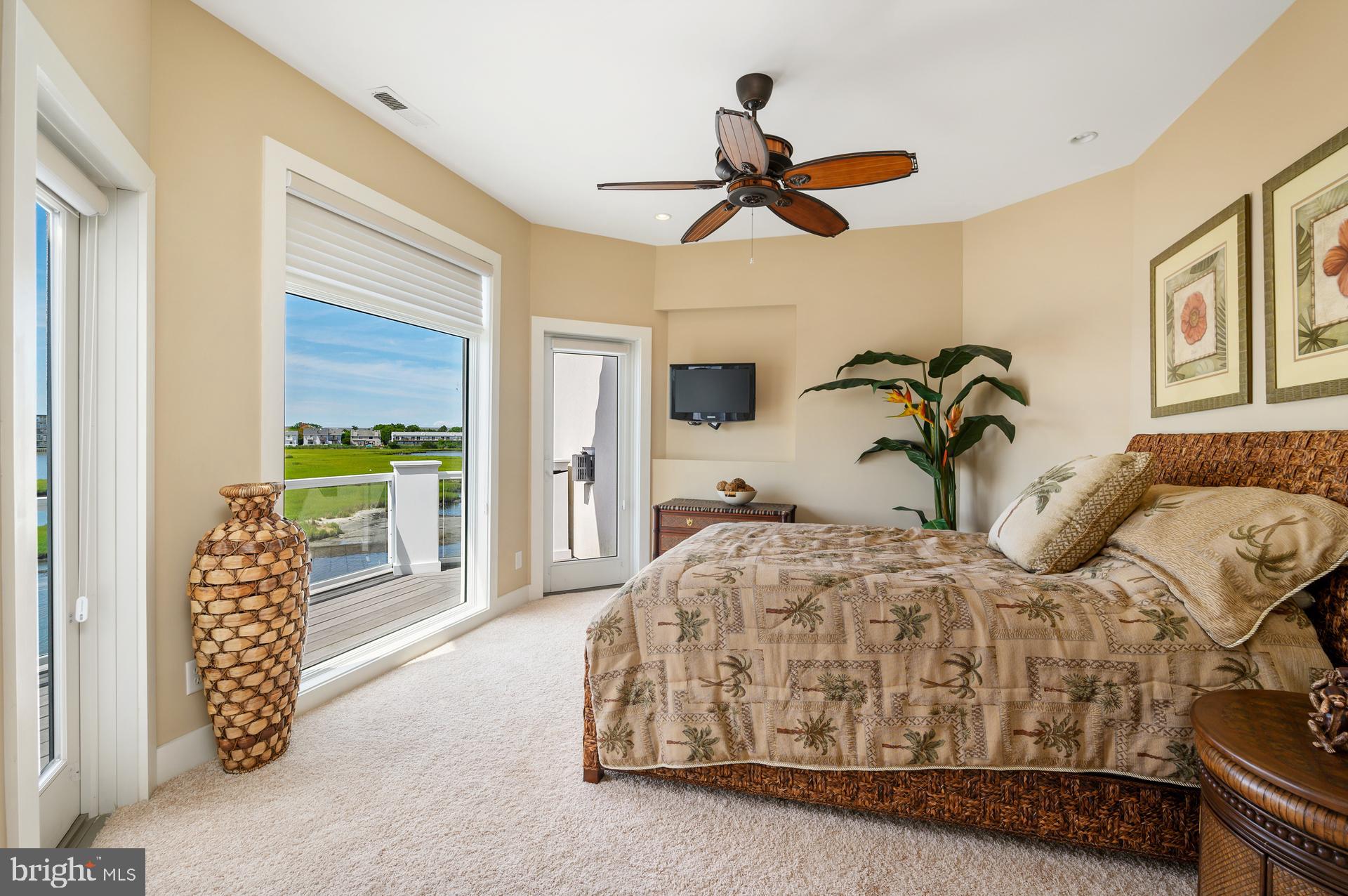 160 Channel Buoy Road Ocean City, MD 21842 - Photo 32 of 71 a bedroom with a bed a chandelier and a window