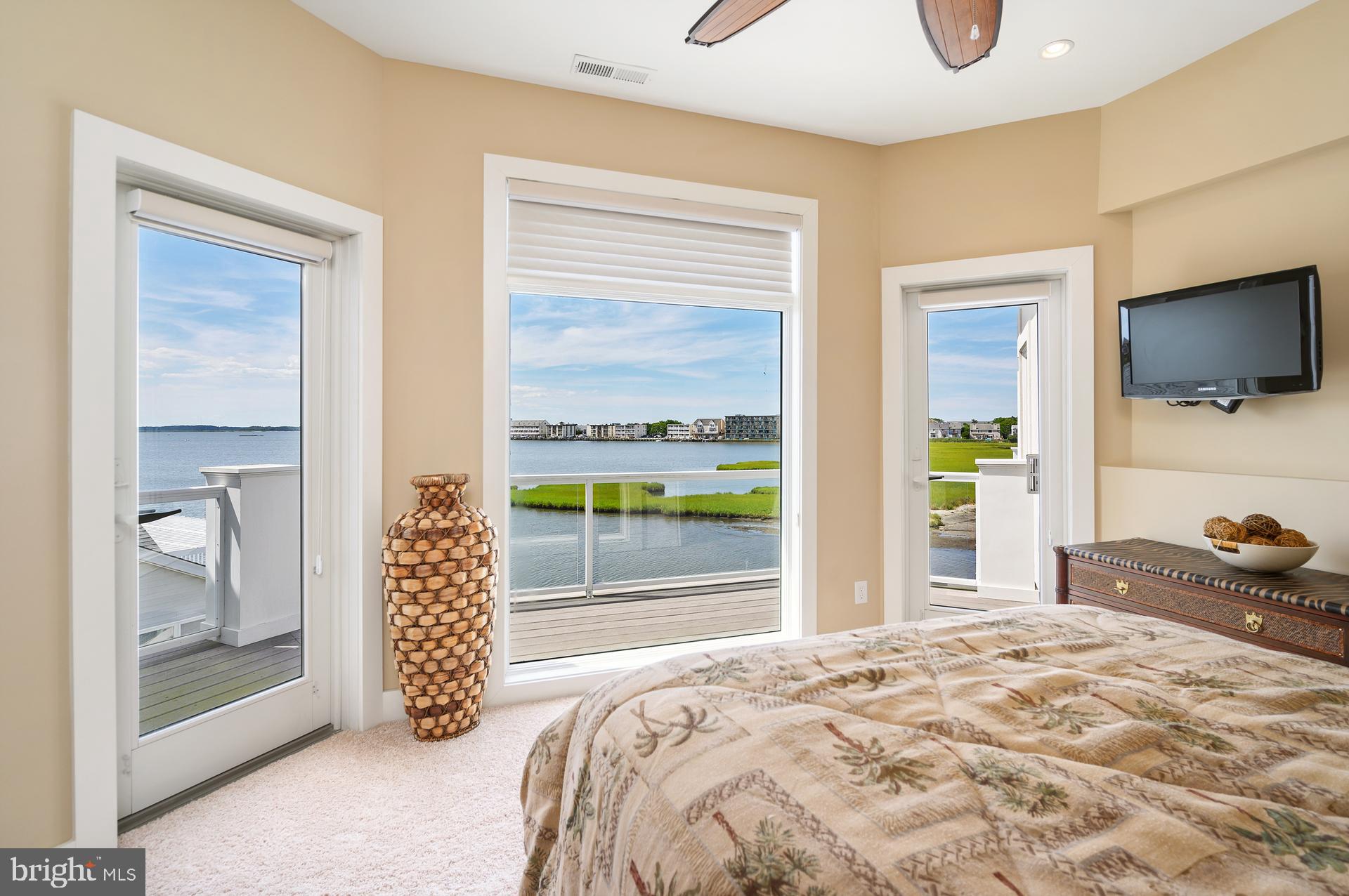 160 Channel Buoy Road Ocean City, MD 21842 - Photo 33 of 71 a bedroom with a bed and large windows