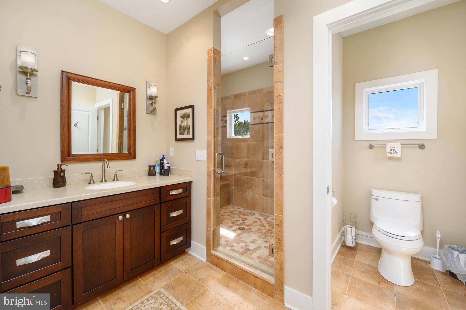 160 Channel Buoy Road Ocean City, MD 21842 - Photo 36 of 71 a bathroom with a toilet a sink and glass door
