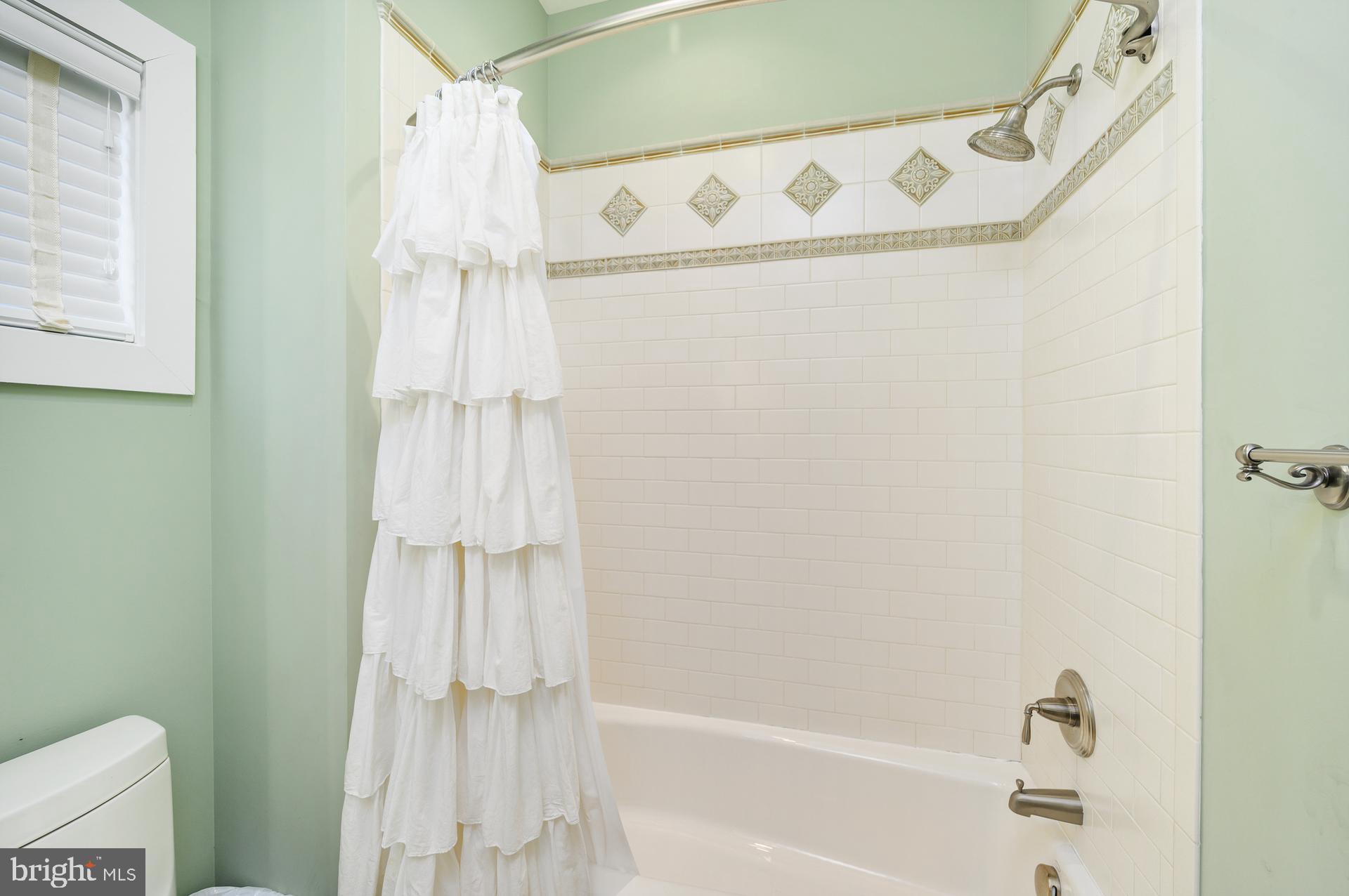 160 Channel Buoy Road Ocean City, MD 21842 - Photo 46 of 71 a bathroom with a shower curtain and a tub