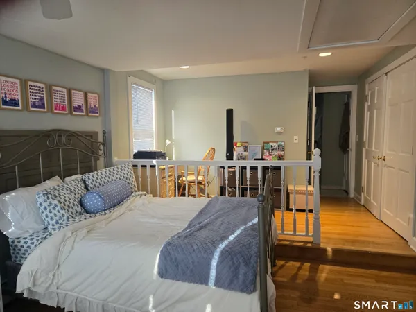 a bedroom with a bed a table and potted plant with the outer view