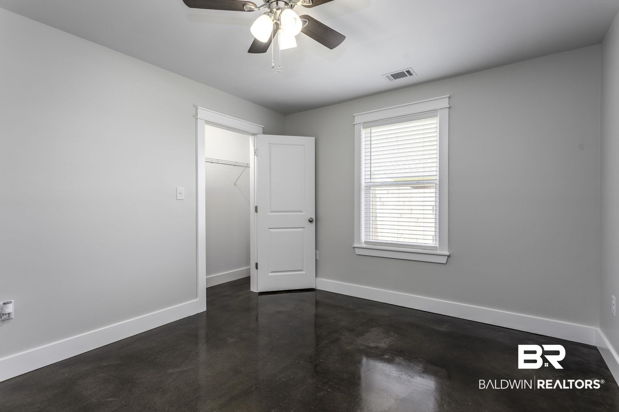 17126 Sugar Loop Foley, AL 36535 - Photo 15 of 28 Unfurnished bedroom with finished concrete floors, ceiling fan, and a spacious closet