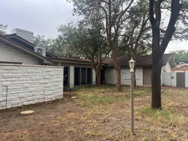 a view of a house with a large tree