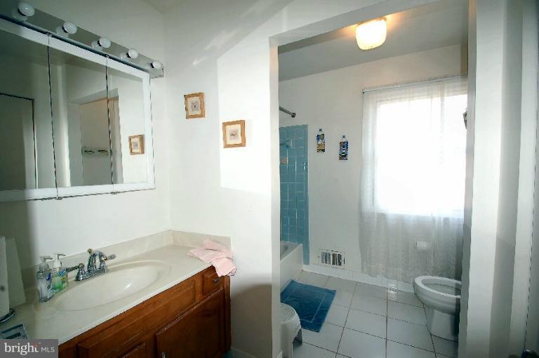 2314 Falling Creek Road Silver Spring, MD 20904 - Photo 11 of 16 a bathroom with a granite countertop sink toilet a mirror and shower