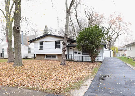 a white house that has a tree in front of it