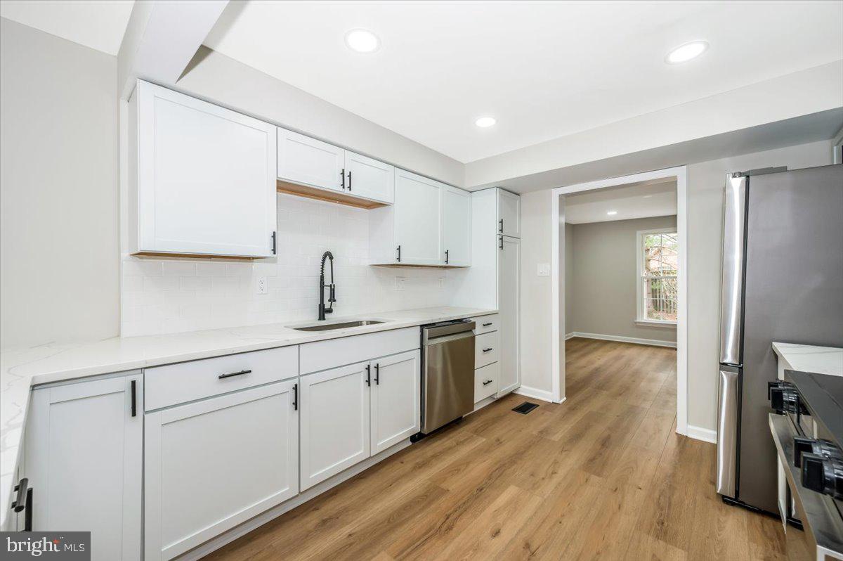 8200 Red Wing Court Frederick, MD 21701 - Photo 7 of 40 a kitchen with white cabinets and sink