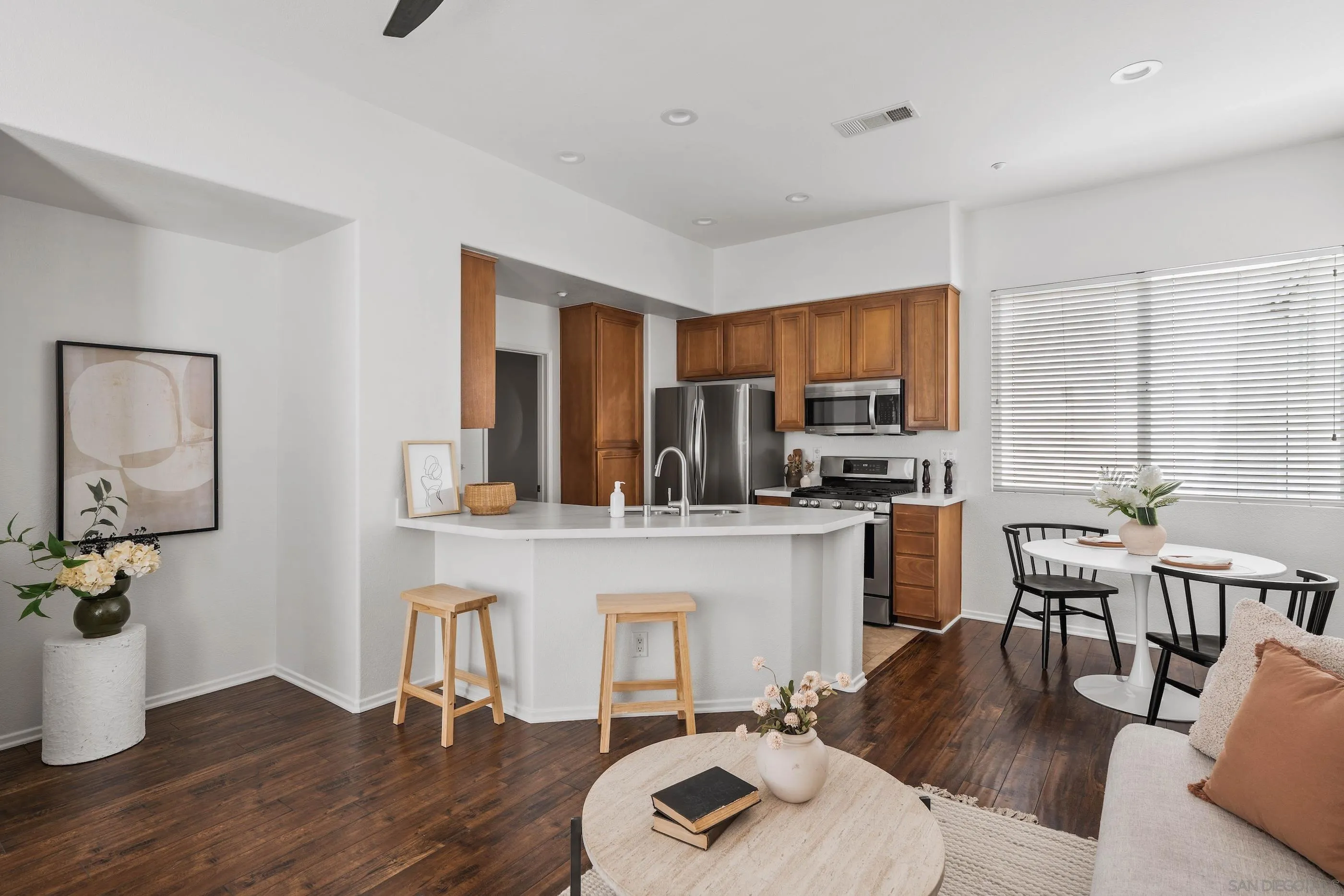 489 Almond Road San Marcos, CA 92078 - Photo 3 of 25 a kitchen with a table chairs refrigerator and microwave