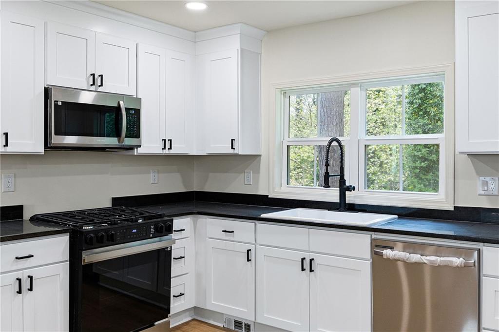 4289 Kimball Road Southwest Atlanta, GA 30331 - Photo 6 of 20 a kitchen with granite countertop a sink a stove a microwave and window