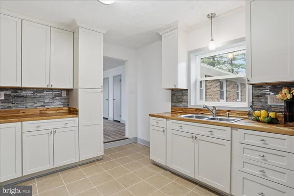 a kitchen with a refrigerator sink and cabinets