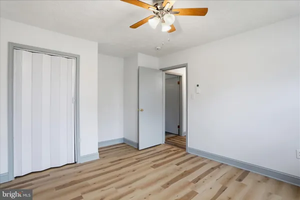 a view of a kitchen with white cabinets and wooden floor