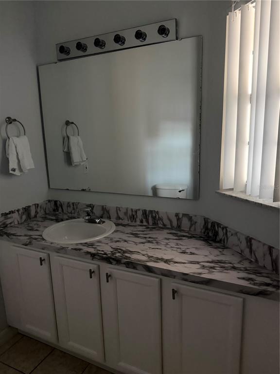 1090 Park Ridge Circle Kissimmee, FL 34746 - Photo 15 of 30 a bathroom with a granite countertop sink and a mirror
