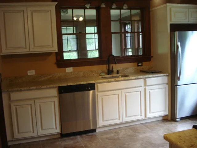 a kitchen with granite countertop white cabinets and sink