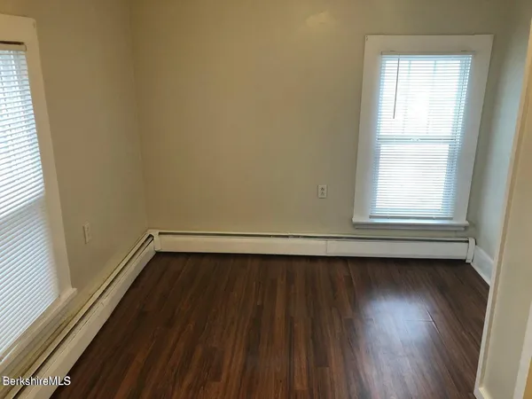 a view of a room with wooden floor and window