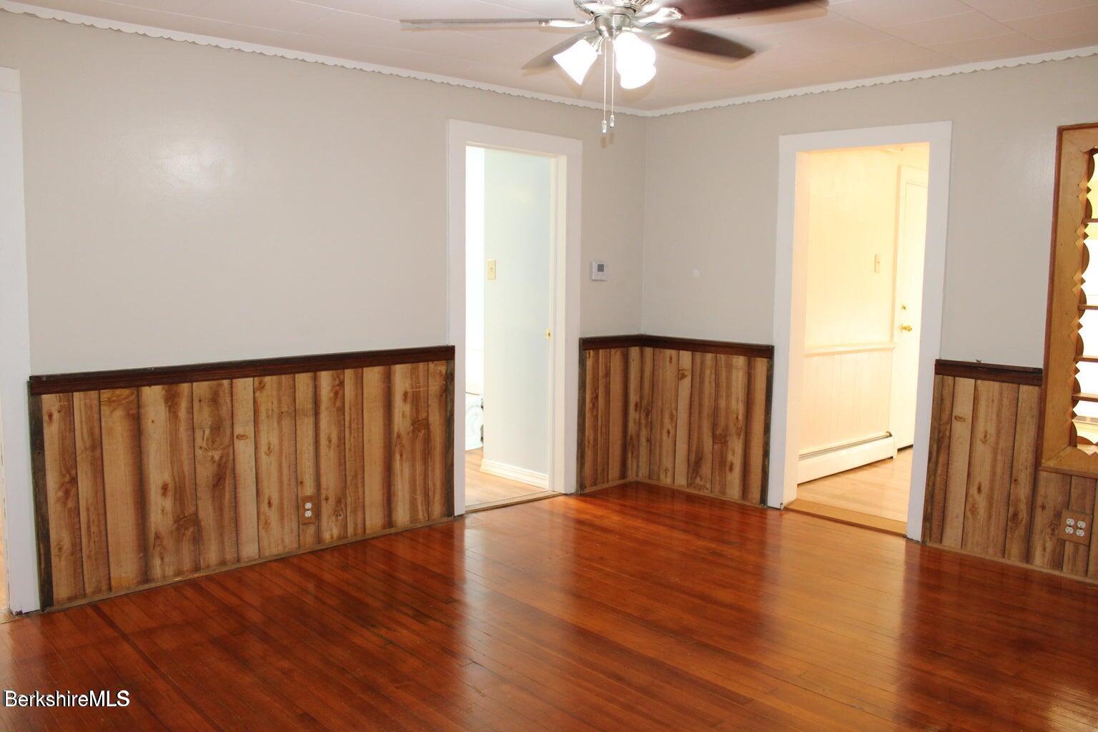 3-5 Pleasant Street Pittsfield, MA 01201 - Photo 16 of 22 an empty room with wooden floor chandelier fan and windows