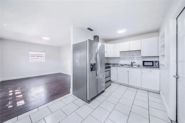 a kitchen with stainless steel appliances a refrigerator sink and microwave