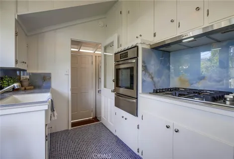 a kitchen with white cabinets and white appliances