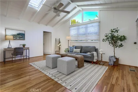 a view of a livingroom with furniture a dinning room and hardwood floor