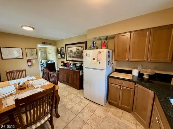 a kitchen that has a dining table chairs and refrigerator