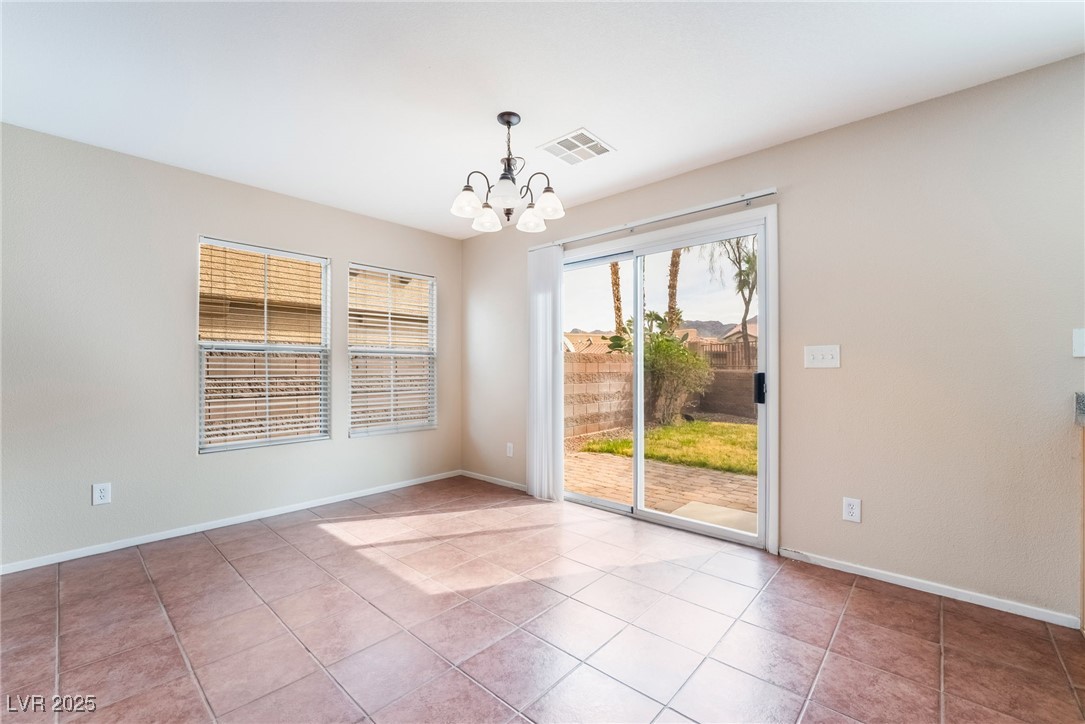 1152 Gecko Road Henderson, NV 89002 - Photo 5 of 32 Spare room with baseboards, tile patterned floors, visible vents, and an inviting chandelier