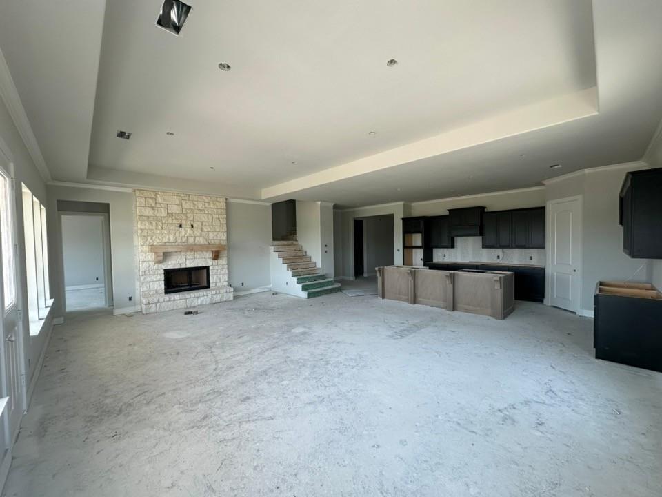 295 Brown Road Leonard, TX 75452 - Photo 10 of 26 Expansive living space featuring a stone fireplace with a substantial mantel, tray ceilings, and recessed lighting