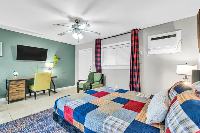a bedroom with a bed a chandelier and a desk