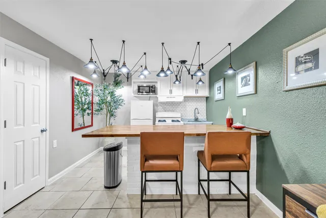 a room with granite countertop a table and chairs in it