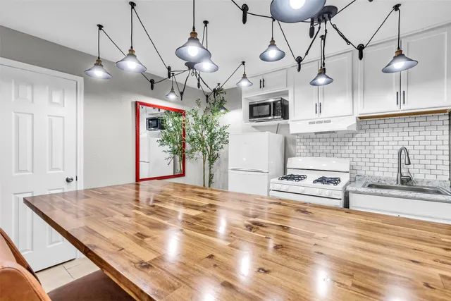 a kitchen with stainless steel appliances granite countertop a sink a stove and a wooden floors