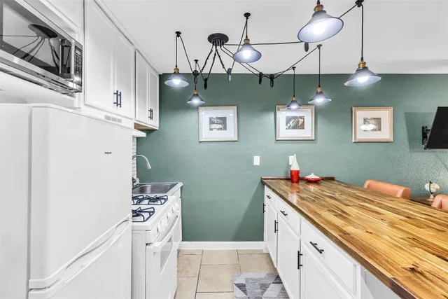 a kitchen with stainless steel appliances a white stove top oven and a dishwasher with wooden floor