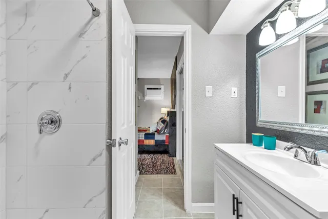 a en suite bathroom with a granite countertop sink and a mirror