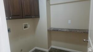 357 East 860 North Hurricane, UT 84737 - Photo 10 of 19 Laundry area featuring upper cabinetry with dark wood-finish doors, a built-in shelf with a stone-look surface, neutral wall paint, and tiled flooring