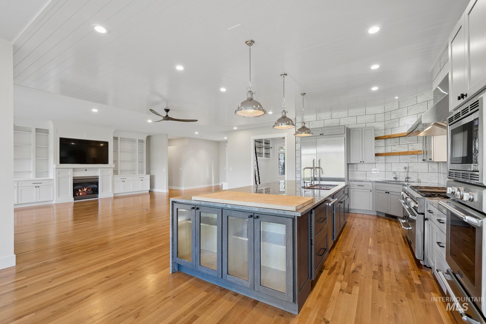 2050 Artesian Road Eagle, ID 83616 - Photo 11 of 49 Gourmet kitchen featuring a large central island with integrated sink, stainless steel appliances, and extensive stone countertops