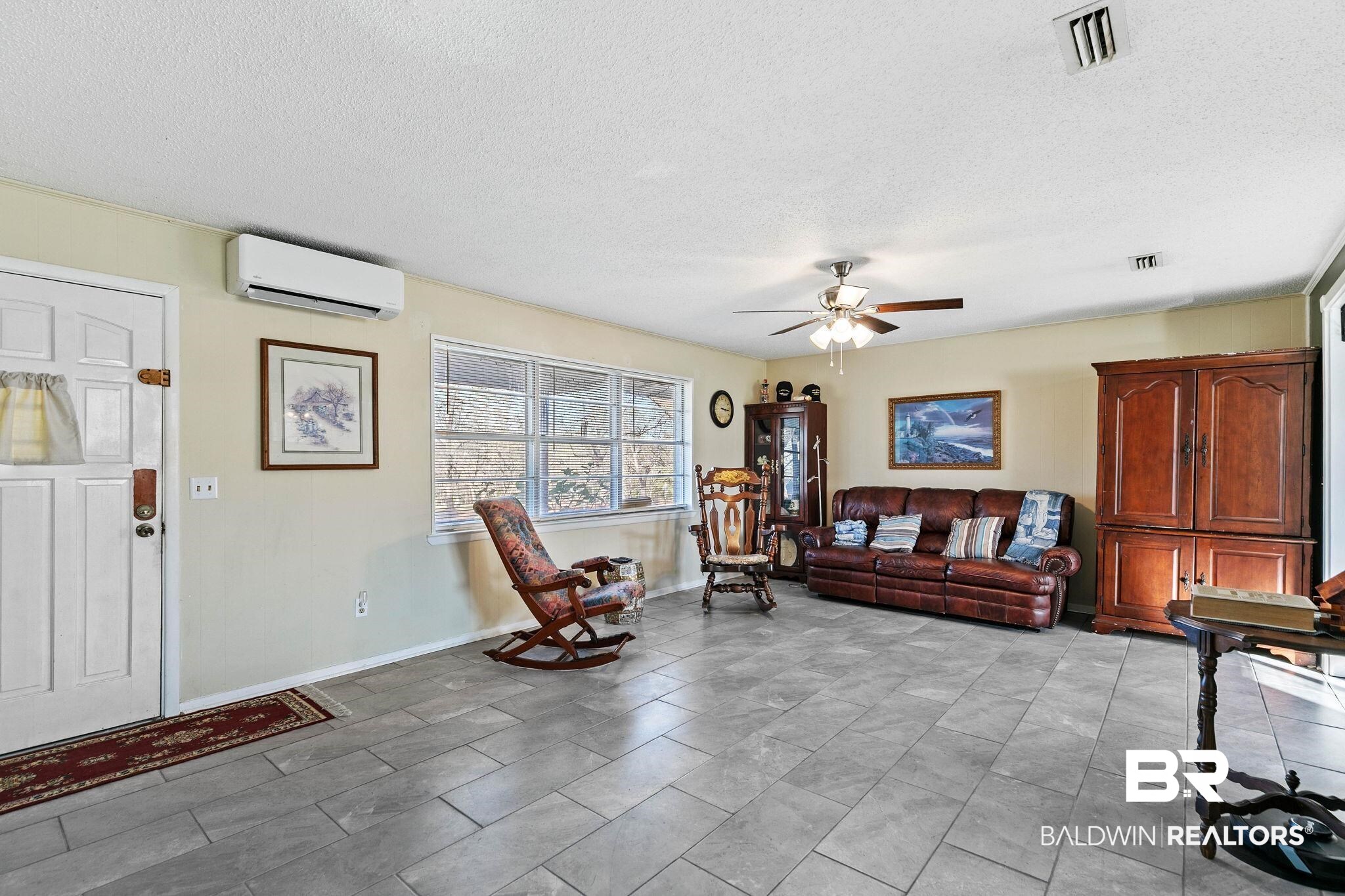 21267 Loop Road Andalusia, AL 36421 - Photo 16 of 72 Living area with a textured ceiling, a ceiling fan, and a wall mounted AC