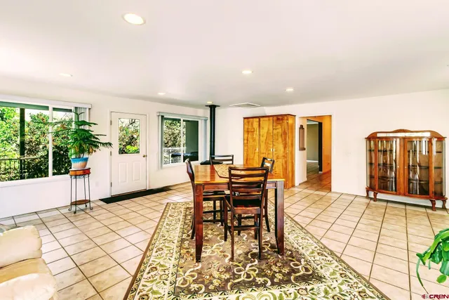 a dining room with furniture and large windows