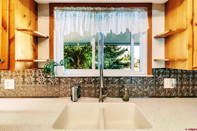 a bathroom with a sink window and a large mirror