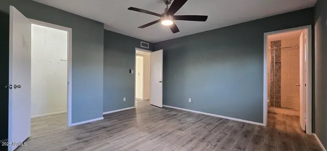 an empty room with wooden floor and windows