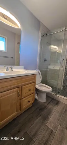 a bathroom with a granite countertop sink toilet and shower