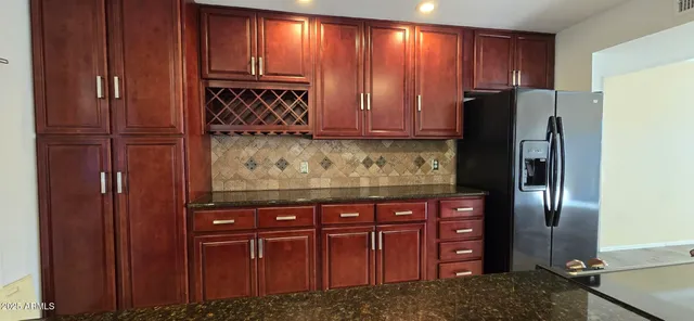 a kitchen with stainless steel appliances granite countertop wooden cabinets and a refrigerator