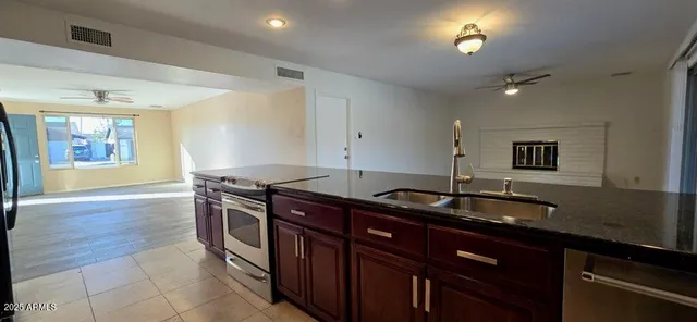 a kitchen with granite countertop a sink and a stove