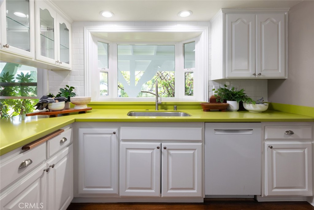 14191 Lambeth Way Tustin, CA 92780 - Photo 16 of 34 a kitchen with white cabinets and a sink