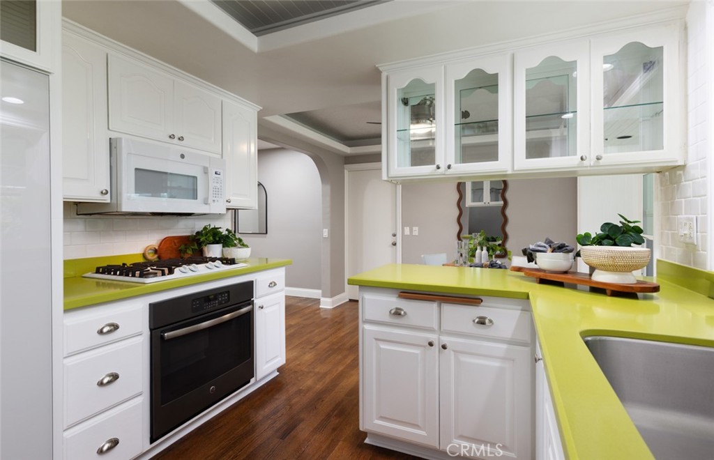 14191 Lambeth Way Tustin, CA 92780 - Photo 17 of 34 a kitchen with a stove a sink and cabinets
