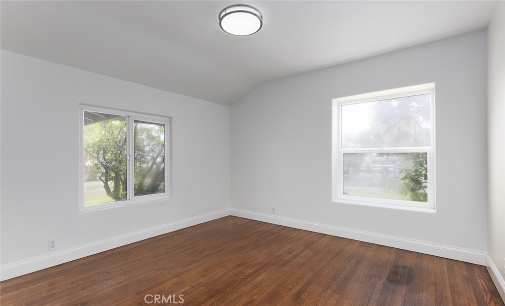 14191 Lambeth Way Tustin, CA 92780 - Photo 19 of 34 an empty room with wooden floor and windows